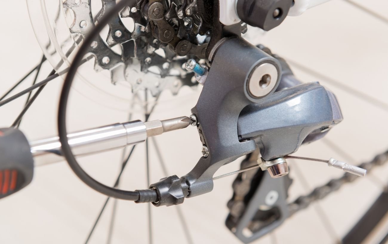 Photo of the limit screws being adjusted on a rear derailleur.