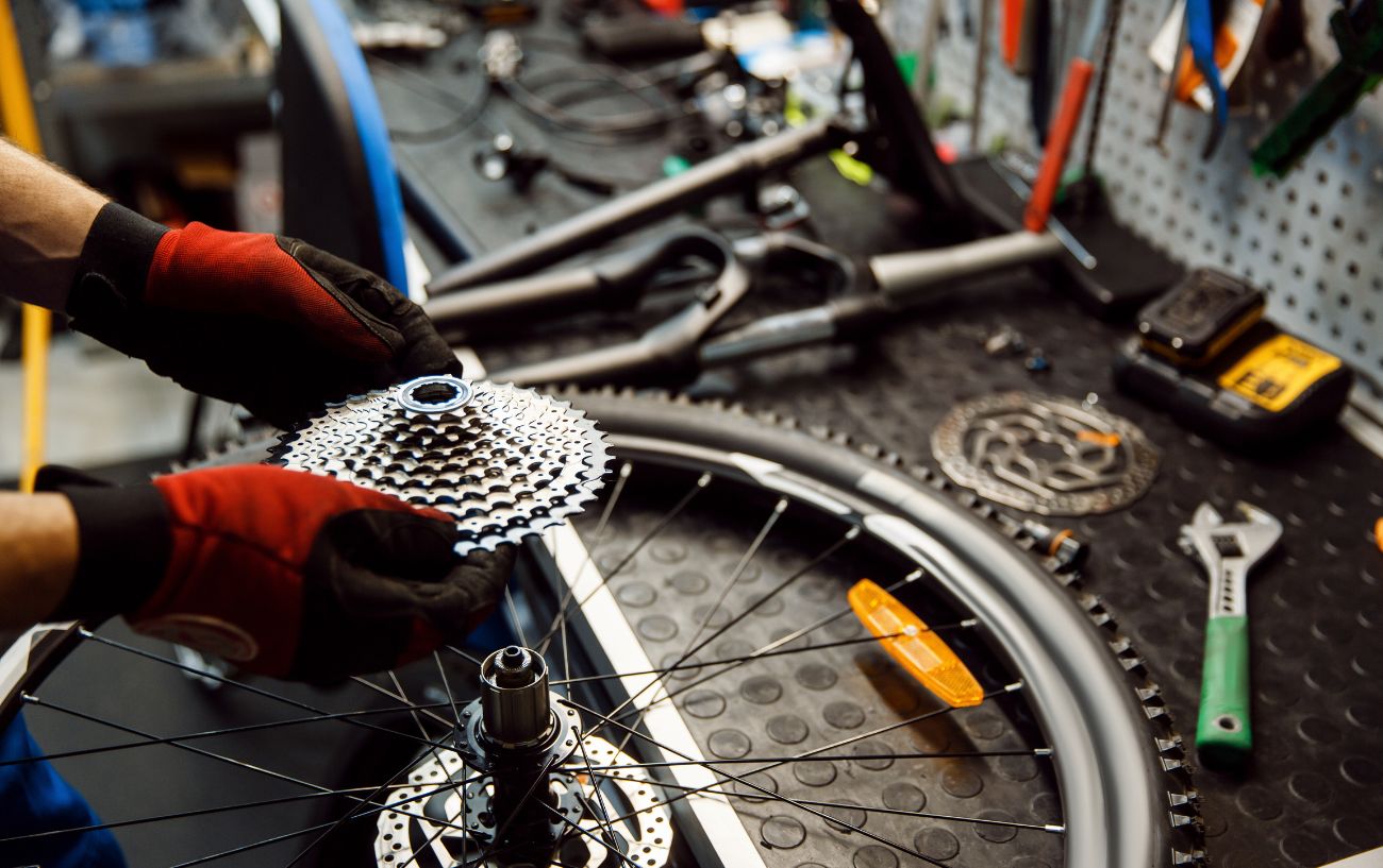 A bike mechanic fits a new cassette on a bike wheel.