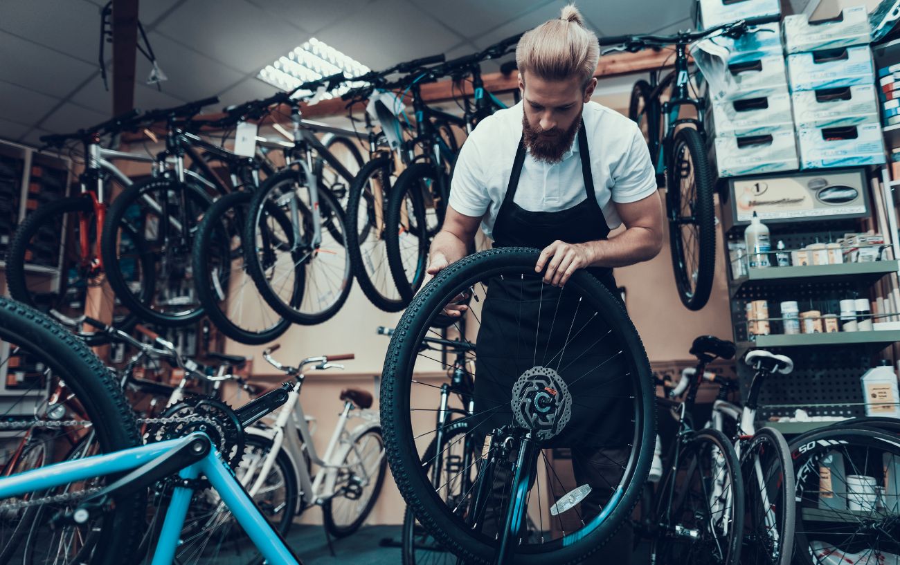 A bike mechanic removes a bike wheel.