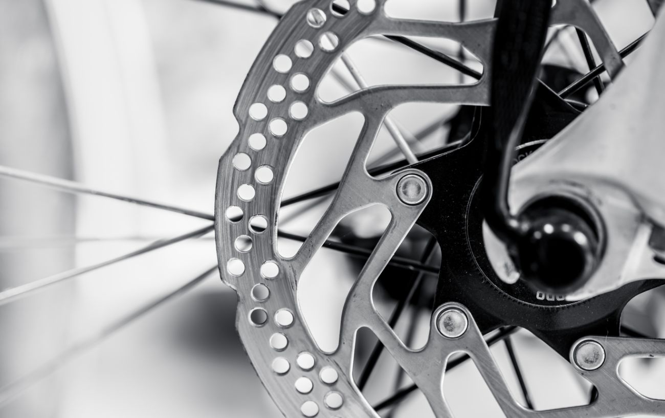 Close-up of a disc brake on a silver bike.