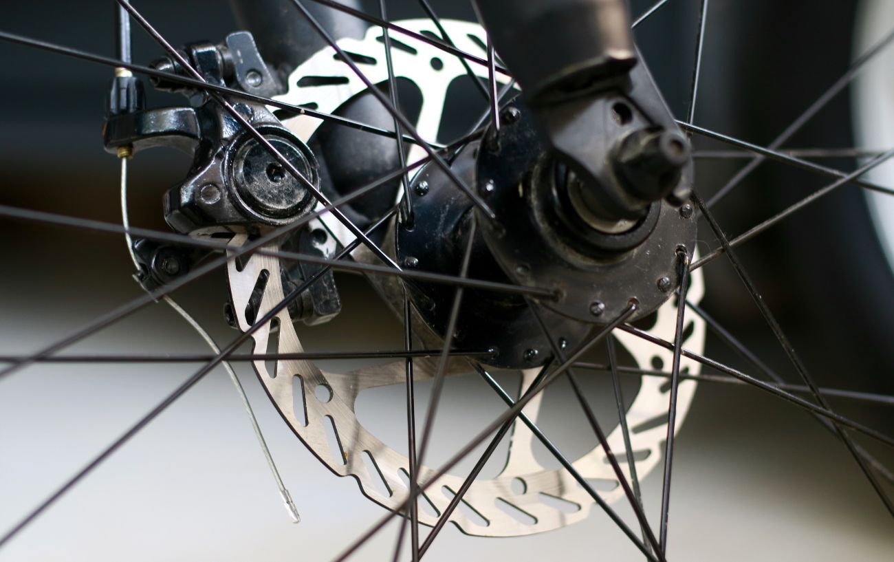 A mechanical disc brake on a brown mountain bike.