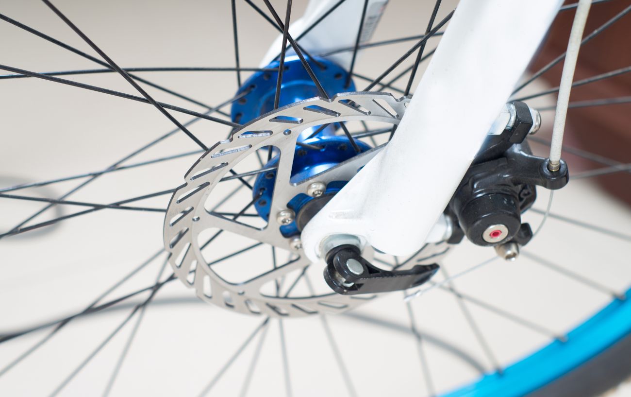 Mechanical disc brake on a white road bike.