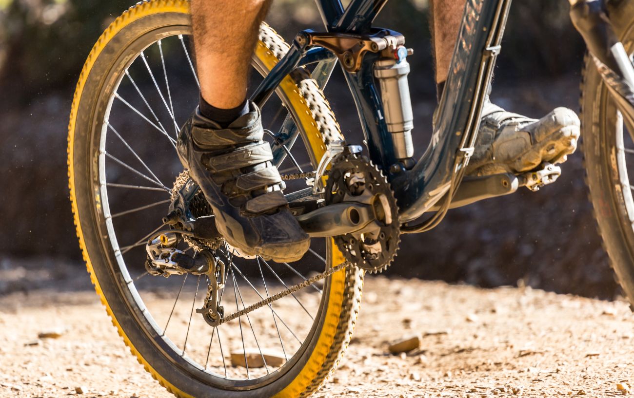 Close-up of the rear wheel of a black full-suspension mountain bike.
