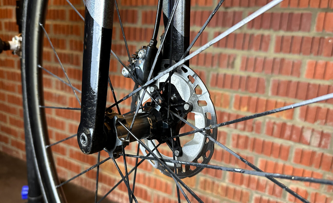 Close-up of a Dura-Ace hub on a road bike wheel with a disc brake.