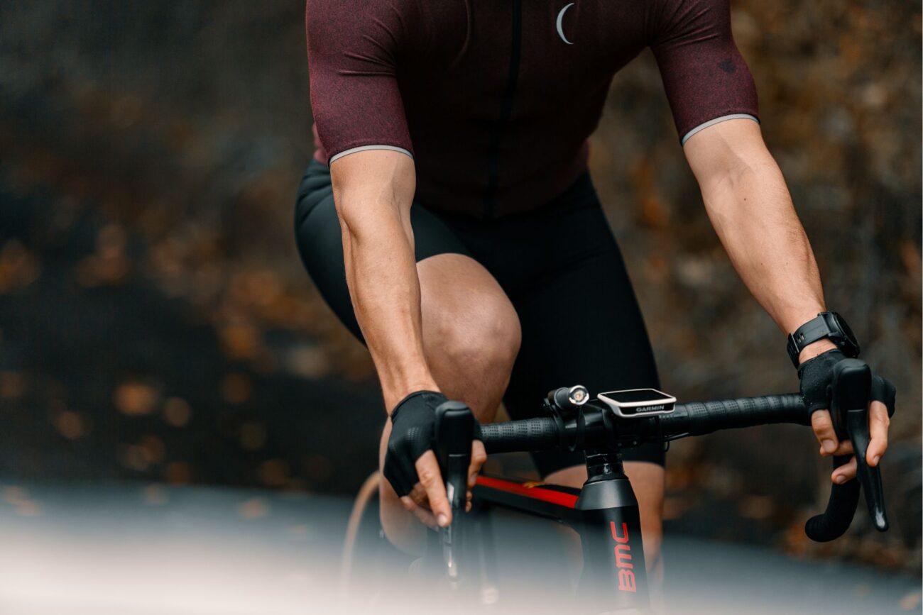 Close-up of a road cyclist in a burgundy jersey.