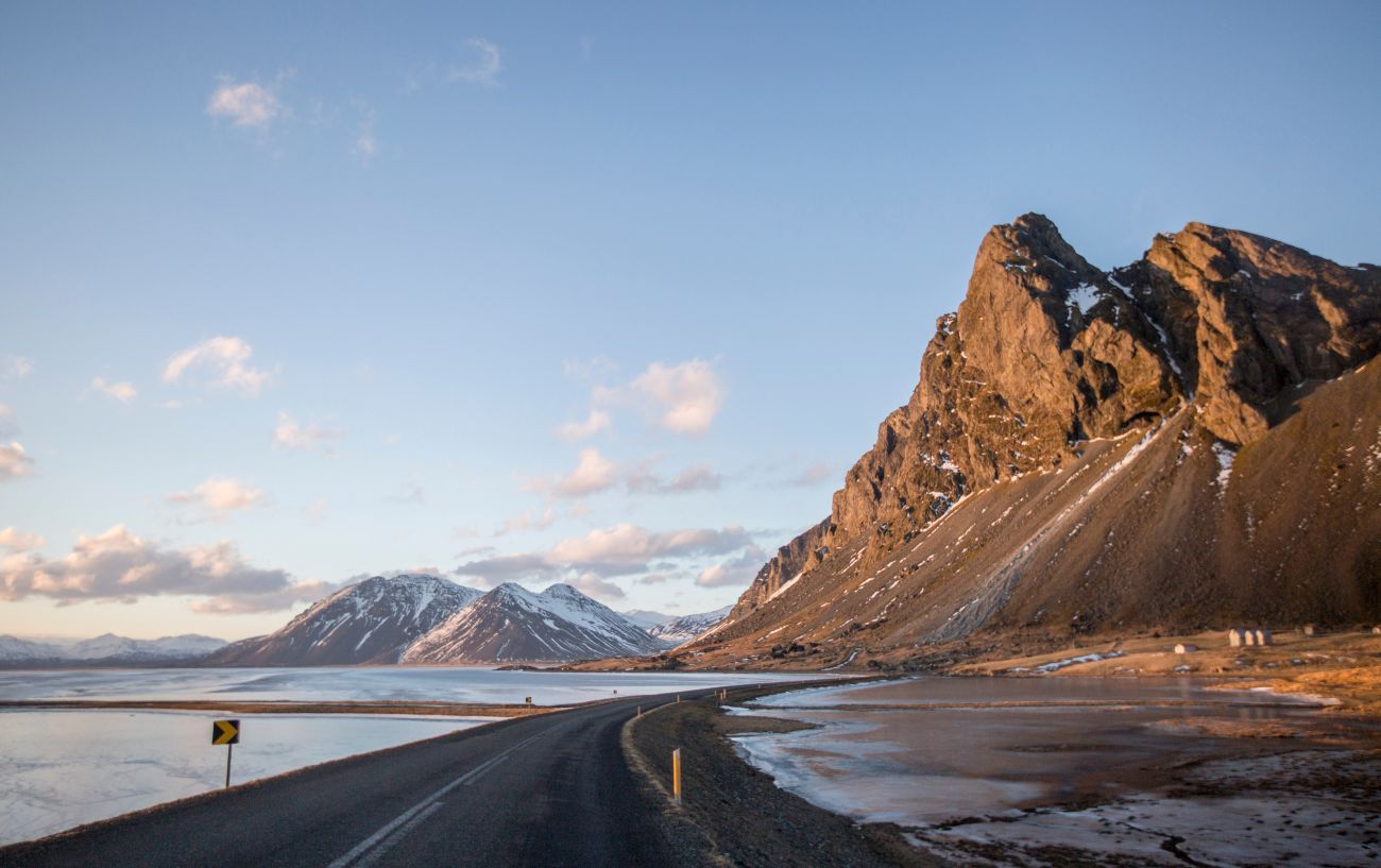 An asphalt road snakes along Iceland's volcanic coastline.
