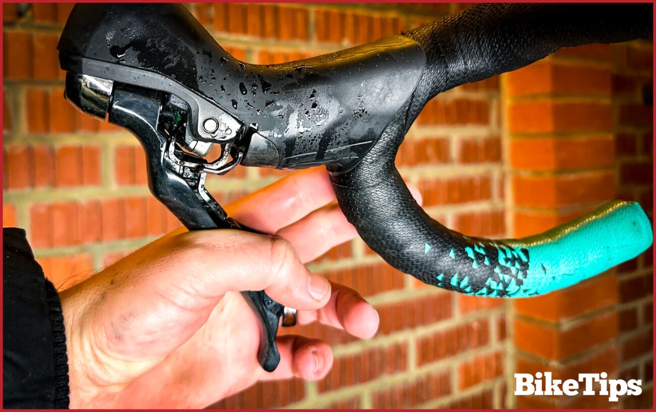 Squeezing the brake lever after installation of the new brake pads.