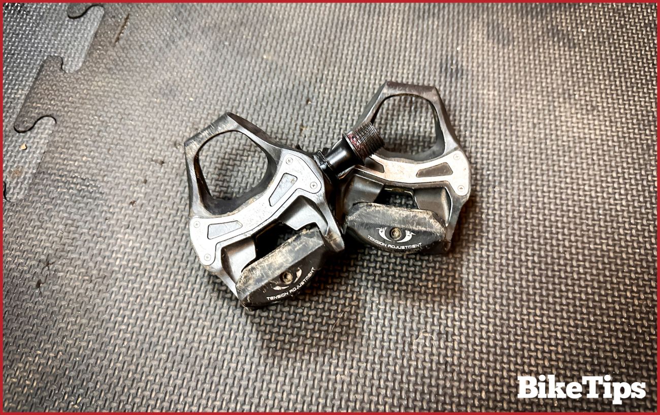 Left and right-sided pedals lie on a black surface.