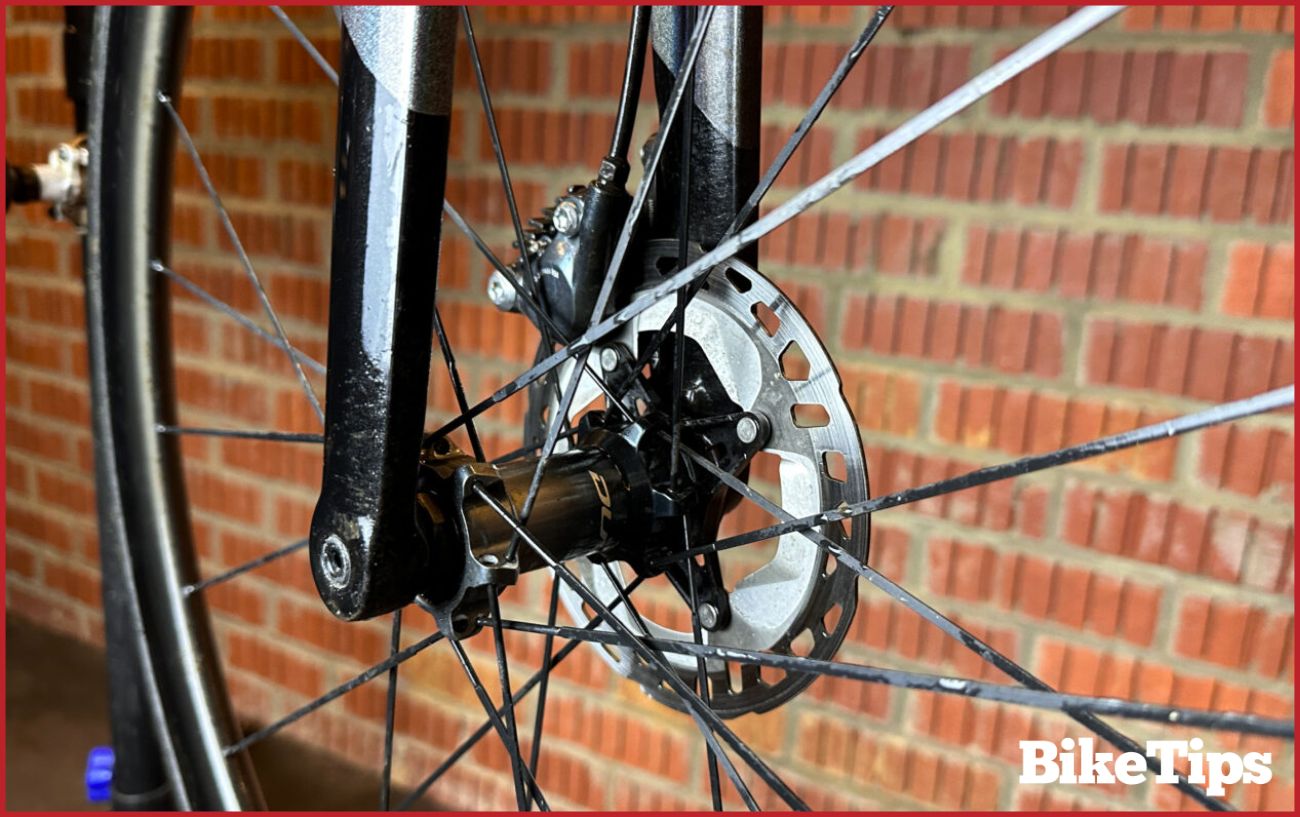 Side-view of a disc brake on a black road bike.