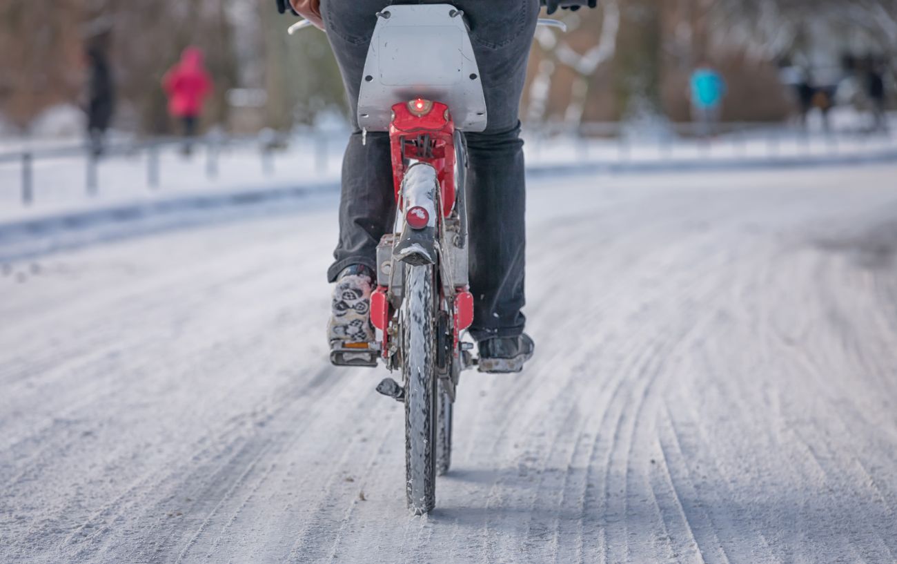A cyclist rides across hard-packed snow.