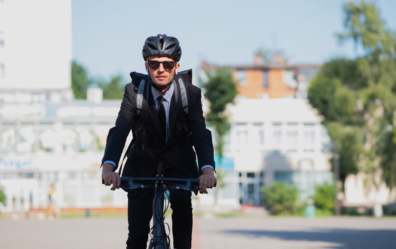 Man in a suit cycling to work on a hybrid.
