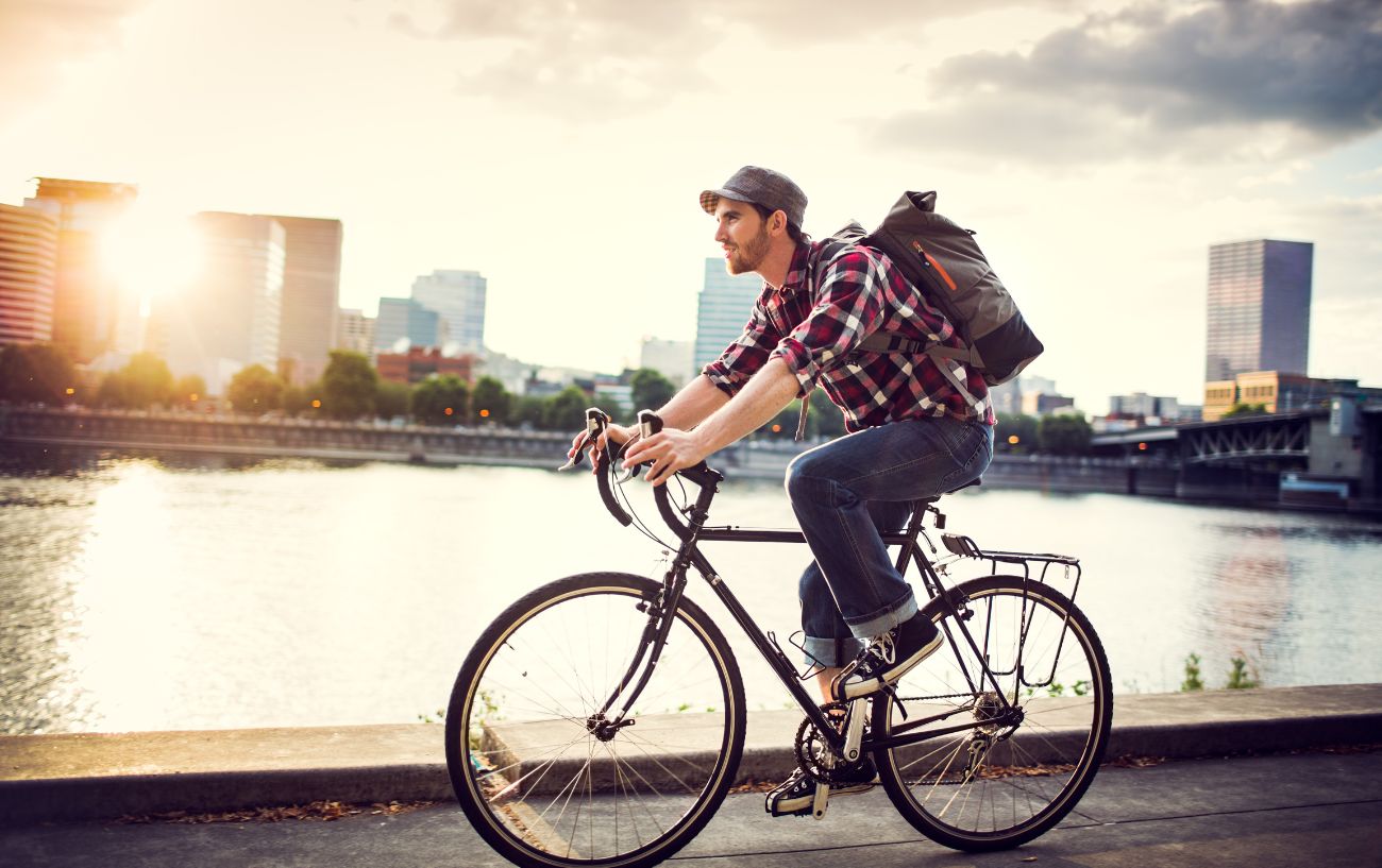 Man cycling to work on a touring bike along a river.
