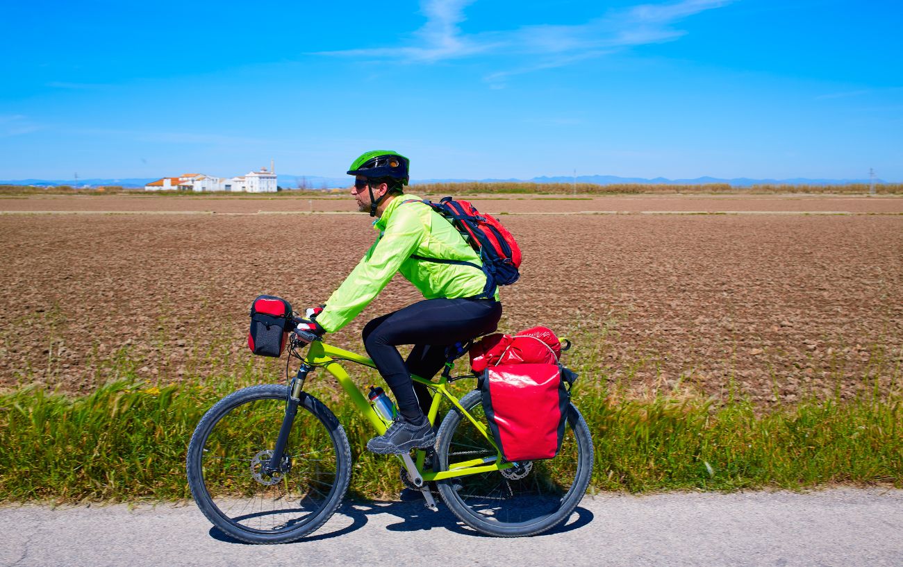 A commuter cycling with pannier bags.