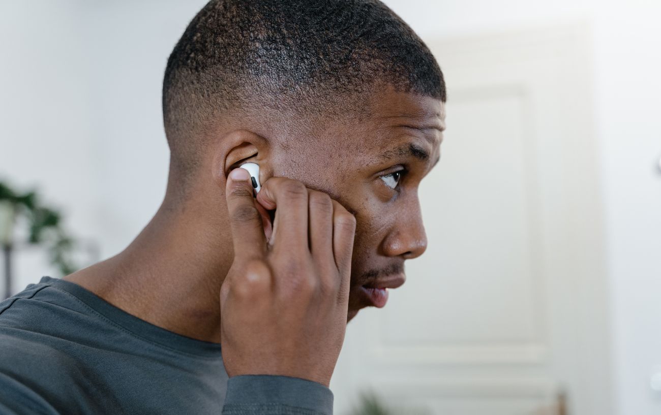 A cyclist adjusts his AirPods.