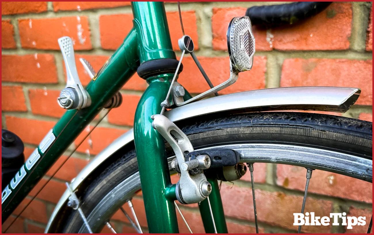 Center-pull rim brakes on a green bike.