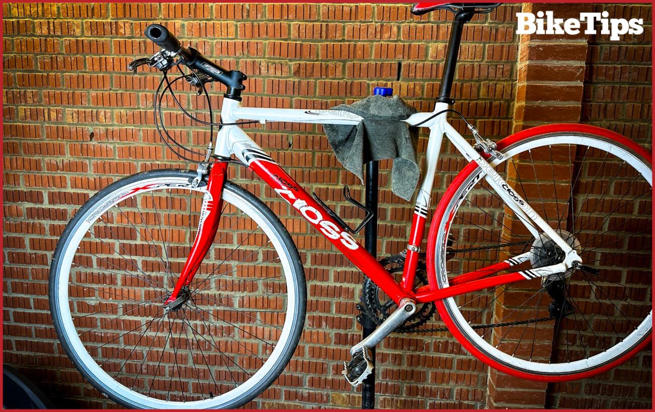 A white hybrid bike sits in a bike stand.