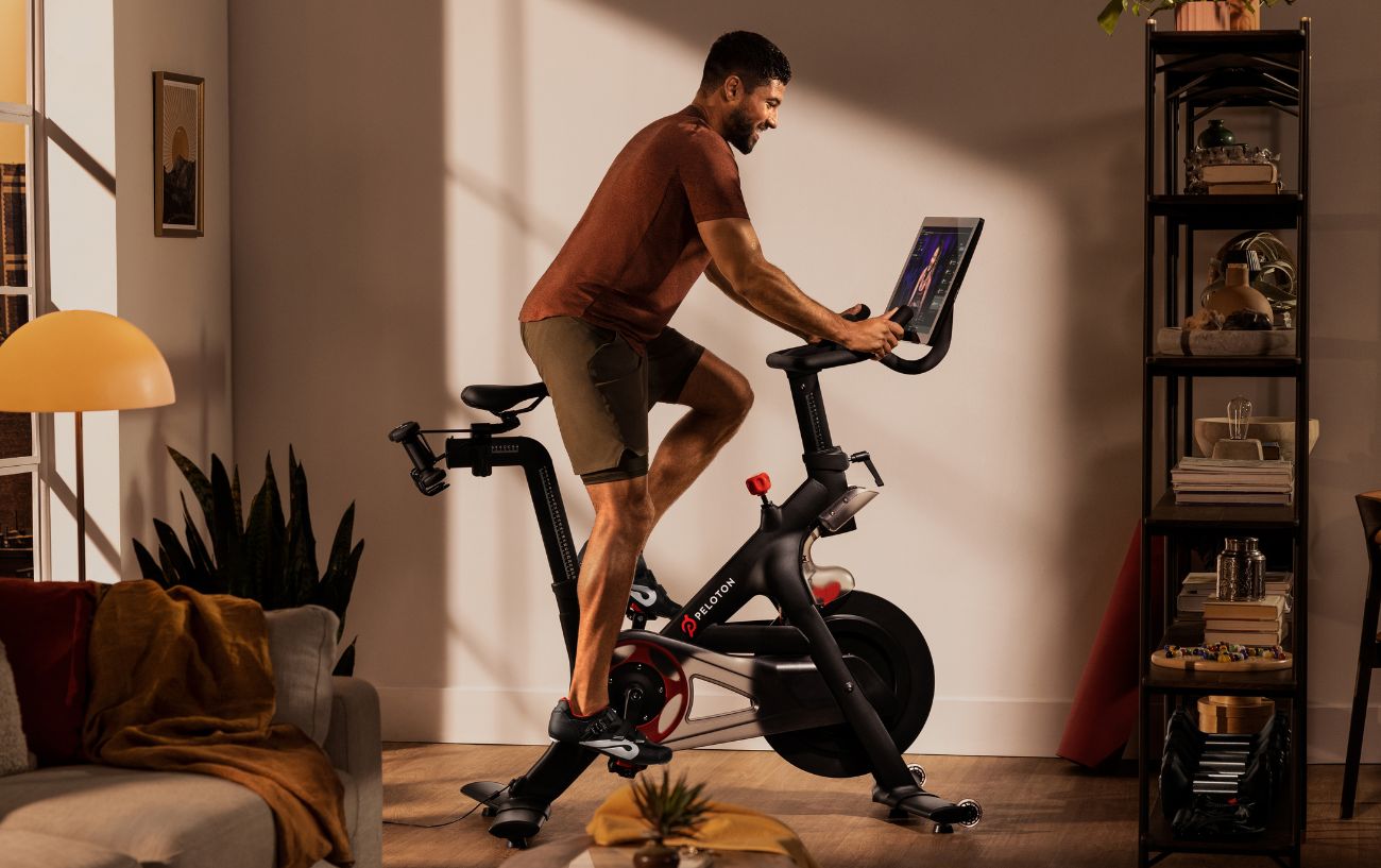 A man rides a Peloton bike in his living room.