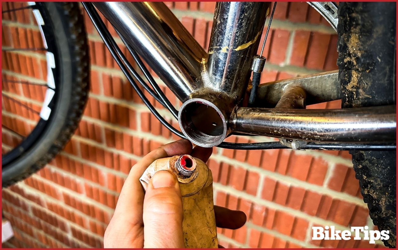 Greasing the threads of the bottom bracket shell.