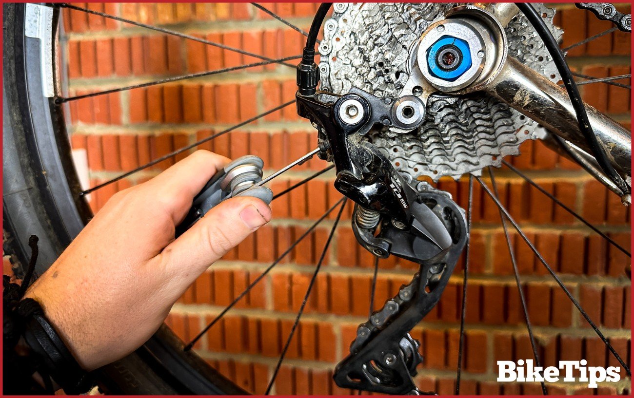 Using an allen key to adjust a B-limit screw in a Shimano 105 rear derailleur.