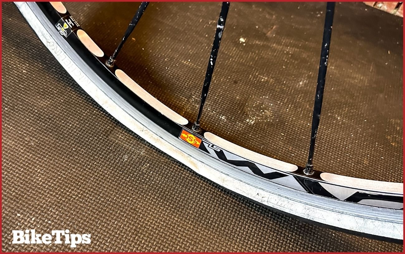 A flat tire on a road bike wheel.