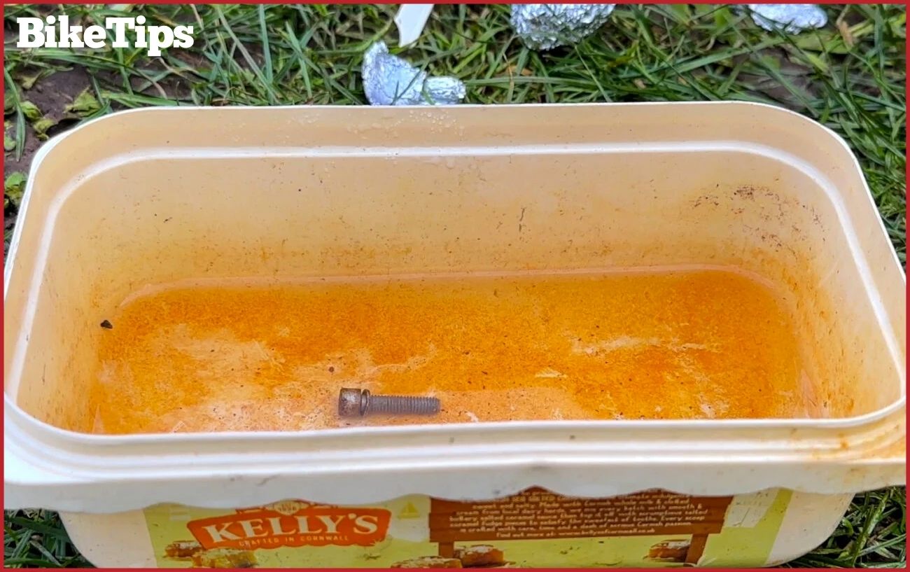 Soaking a rusty bolt in vinegar.