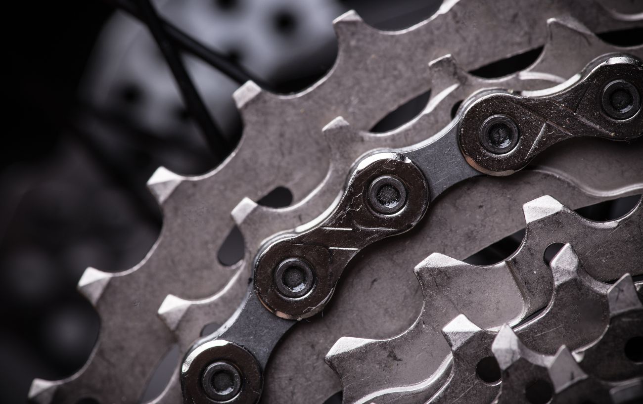 Close-up of a silver bike chain on a cassette.