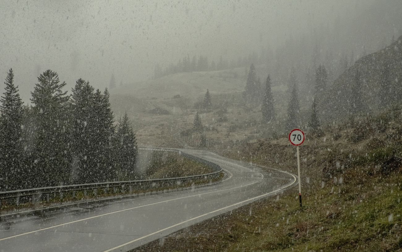 A road stretches up a mountain in a torrential downpour.