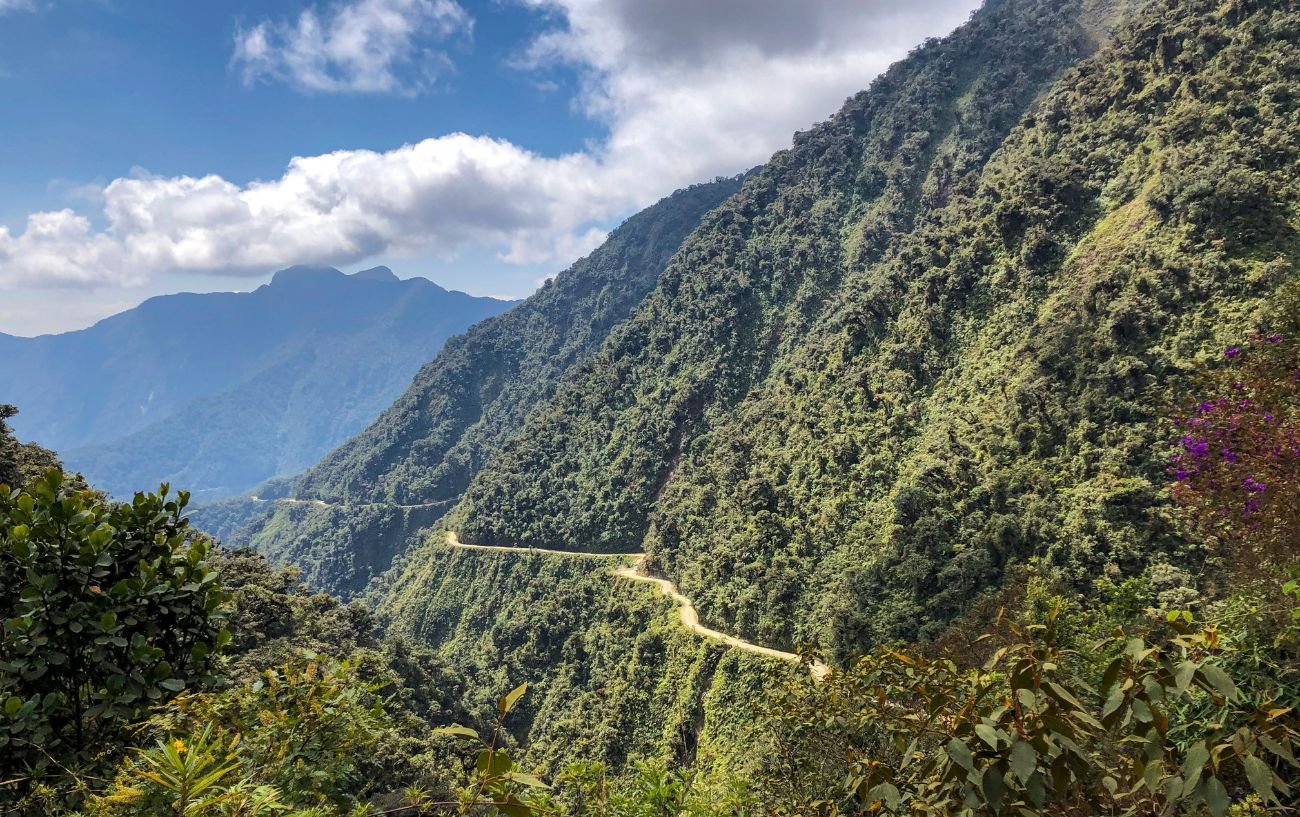 Death Road in Bolivia cuts in the jungle-covered mountainside.