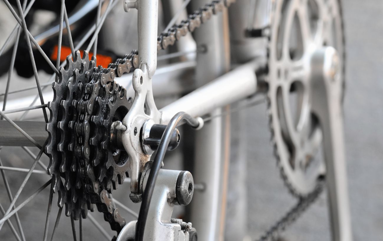 A grey freewheel on a white bike.