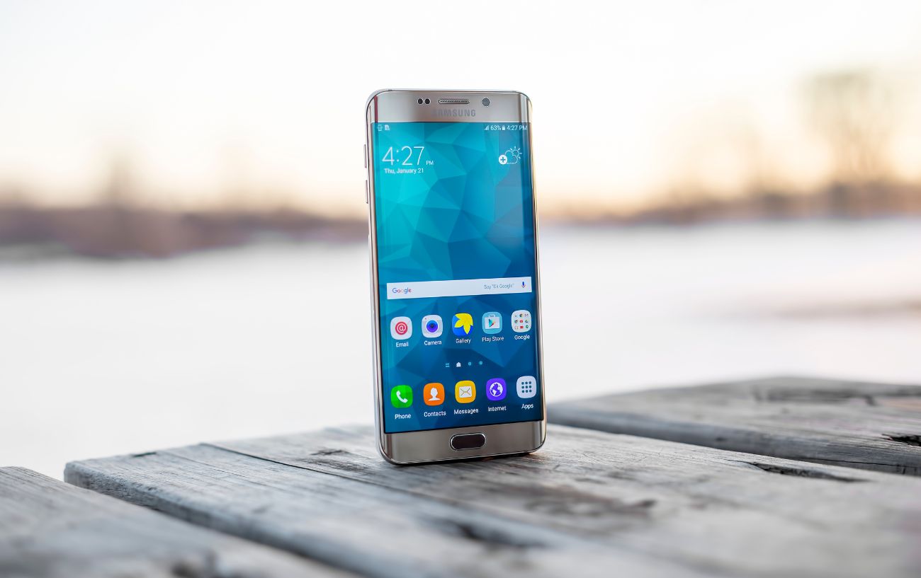An Android phone sits on a wooden table.