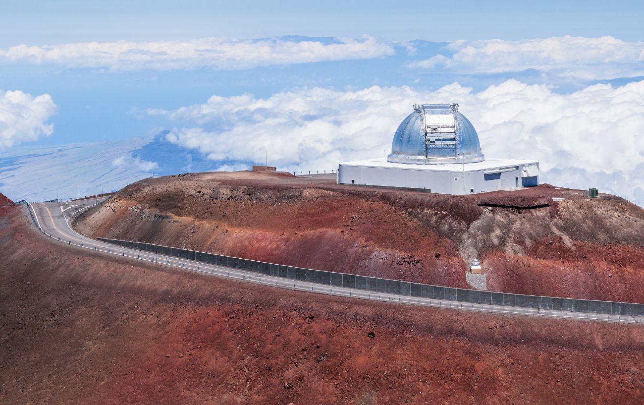 View of the summit of Mauna Kea with clouds below.