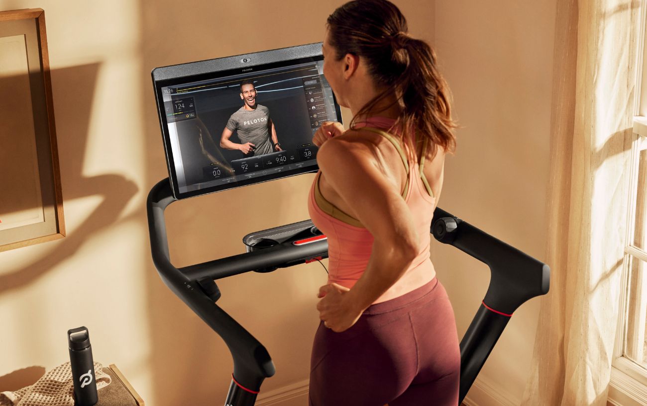 A woman runs on her Peloton Tread machine.