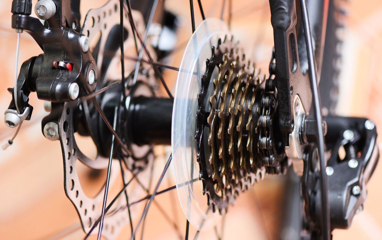 Close-up of the rear wheel of a black bike with disc brakes.
