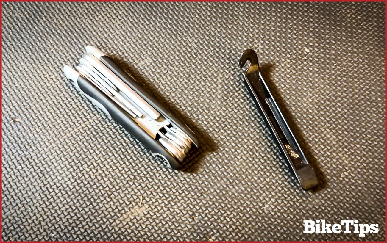 An Allen key set next to a tire lever on a workshop floor.