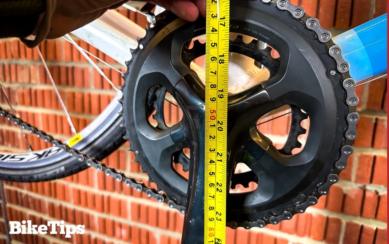 Measuring the seat height at the bottom bracket of a road bike in a stand.