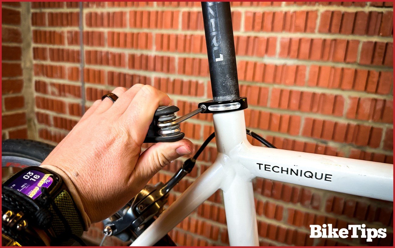 A cyclist tightening the seat post collar with an Allen key set.