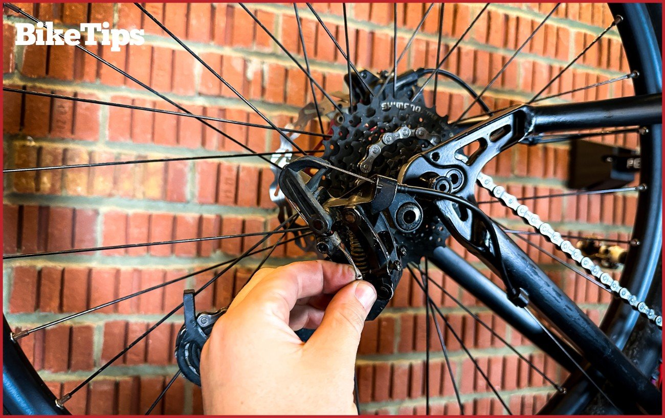 A derailleur cable being adjusted on a mountain bike.