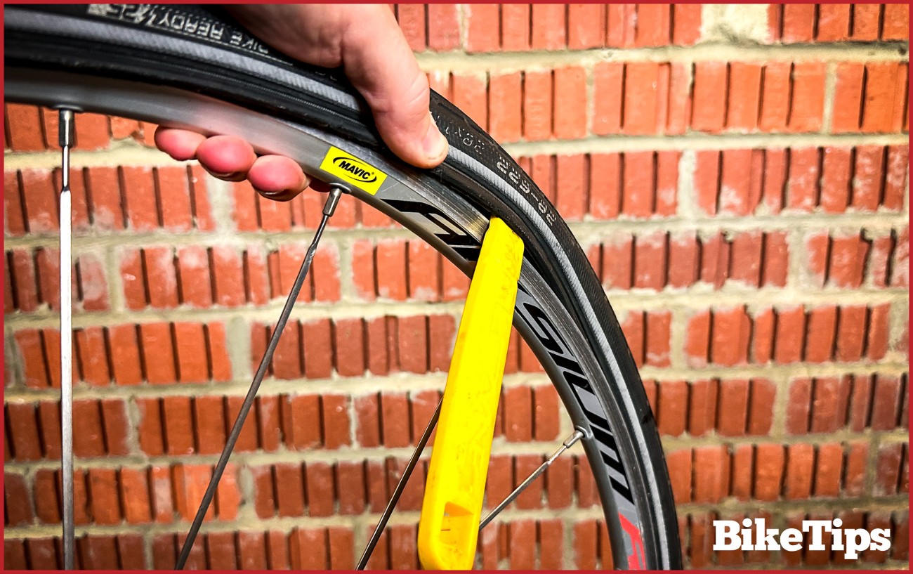 Demonstrating how to change a bike tire using bike levers.