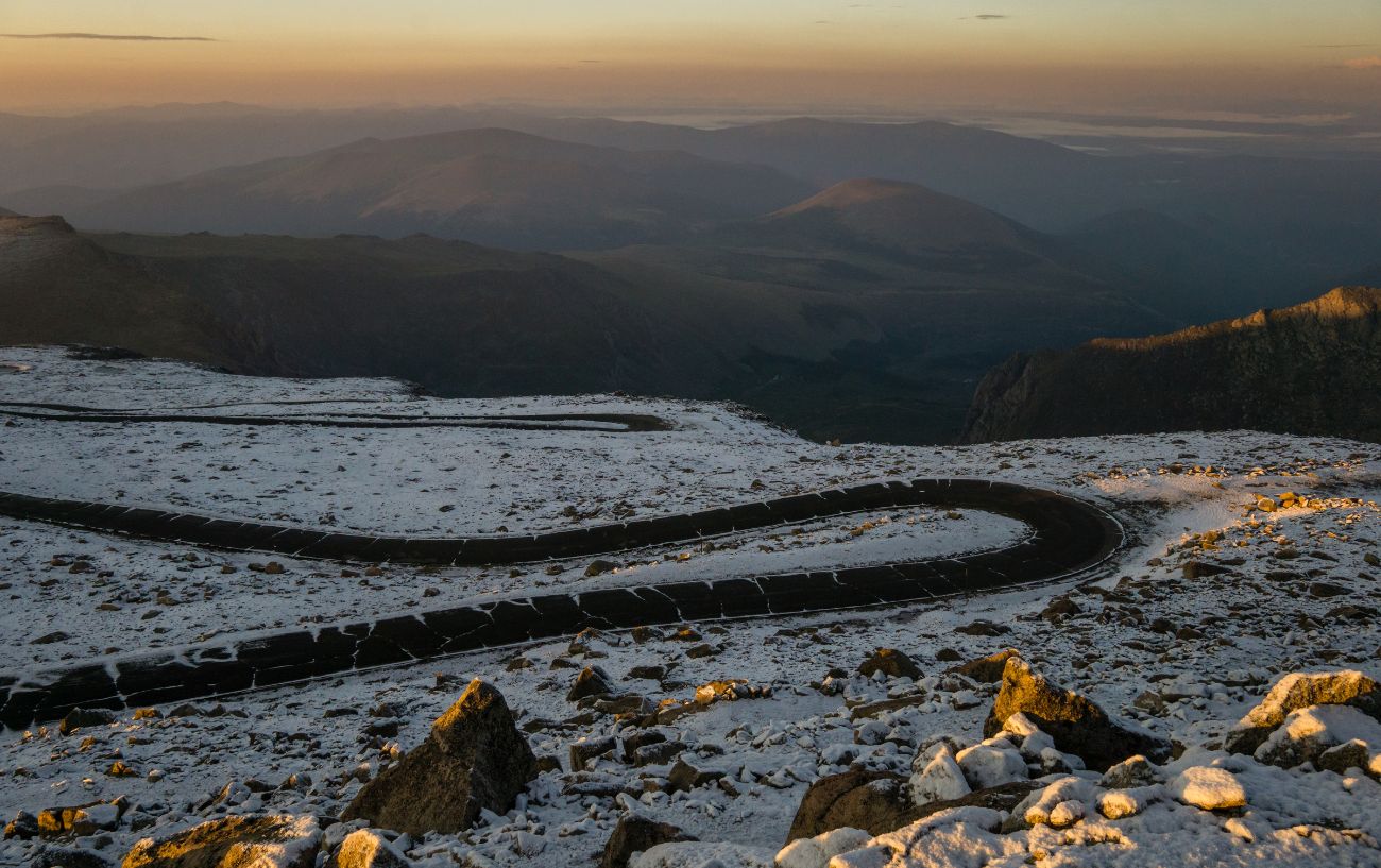 A snow-covered hairpin bend near the summit of the Mount Evans Scenic Byway.