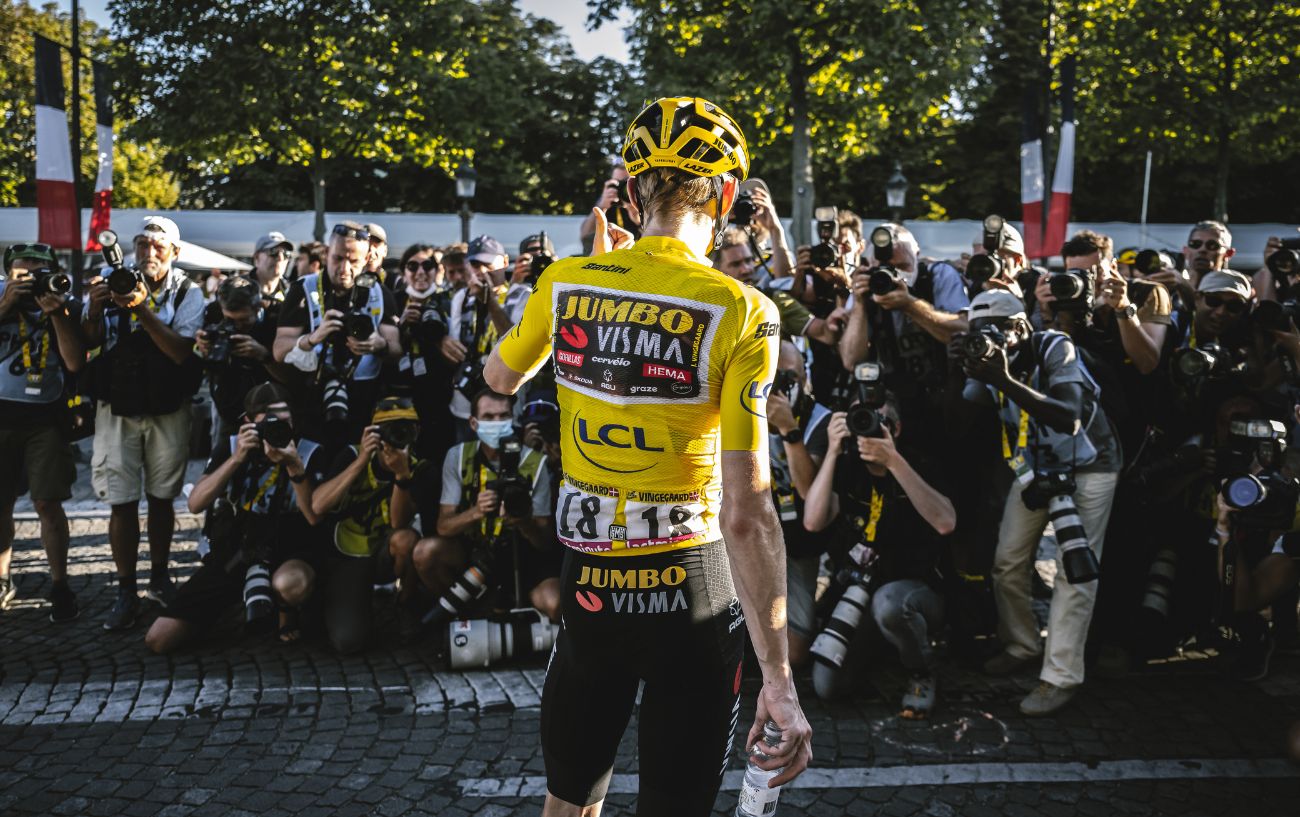 Jonas Vingegaard faces the press in the yellow jersey.