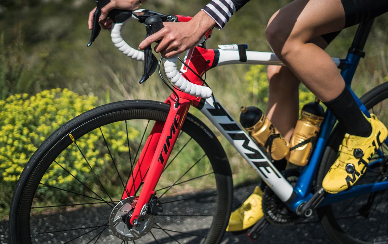 A high-end TIME bike is being cycled on an asphalt road.