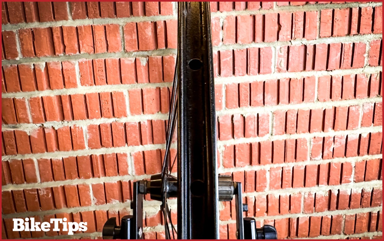 Checking the lateral deviation of a bike wheel while it is in a truing stand.