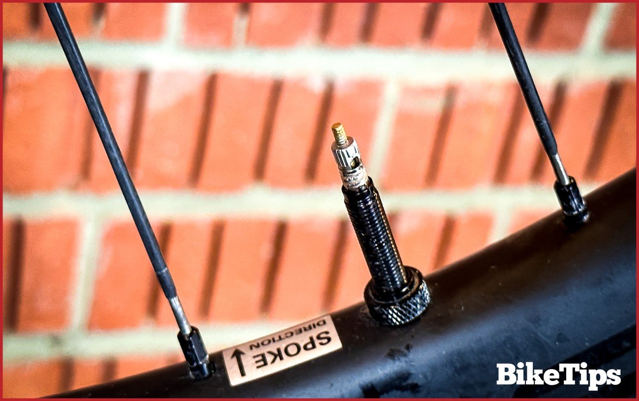 A Presta valve without a cap on a carbon aero wheel.