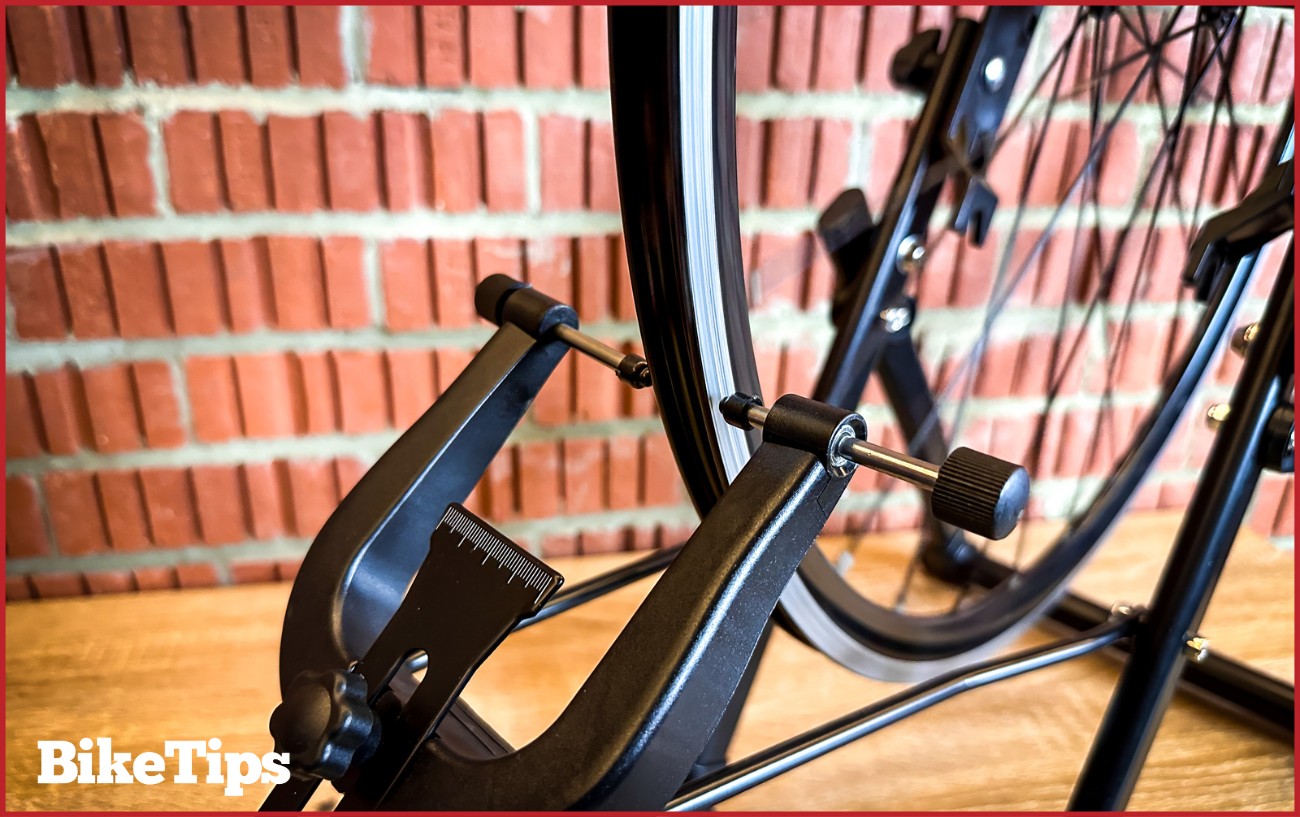 Bike wheel in a truing stand being worked on.
