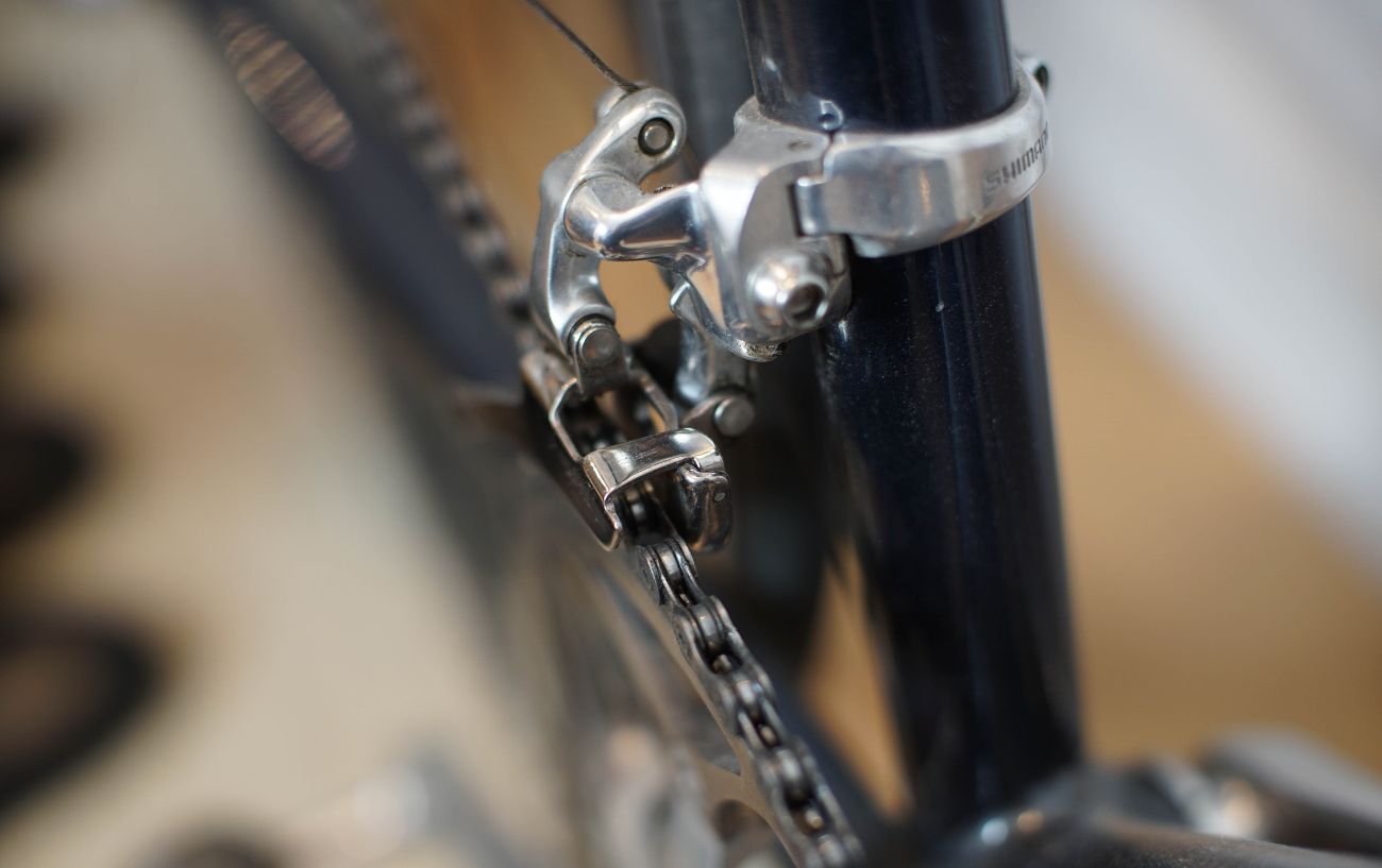 Close-up of the front derailleur on a navy road bike.