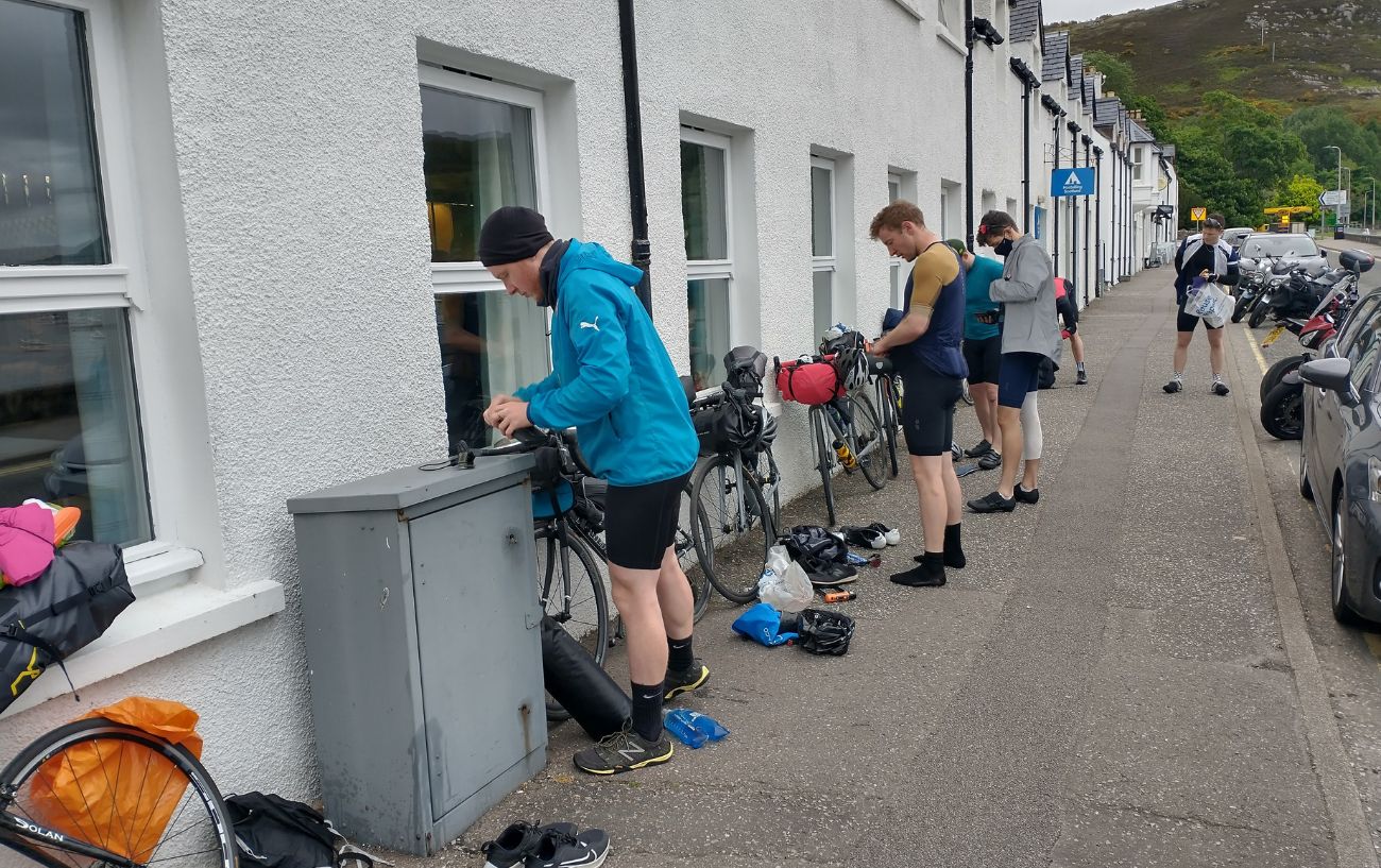 A group of cyclists pause in a town on the North Coast 500.