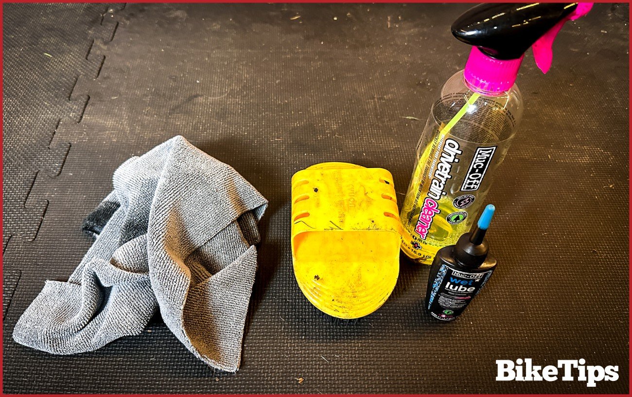 Bike cloth, degreaser, bike lube, and a brush on a mat.