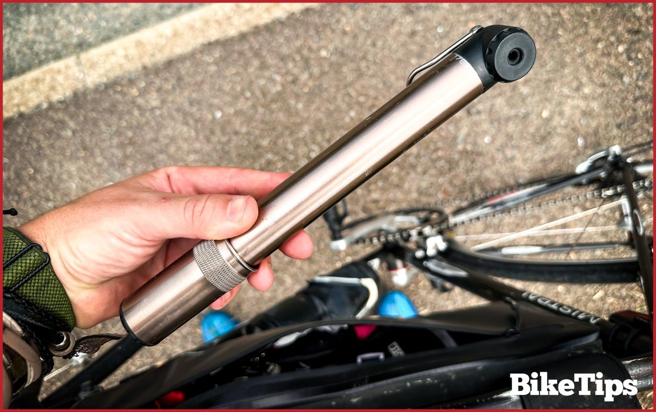 A road bike pump with a bike in the background.