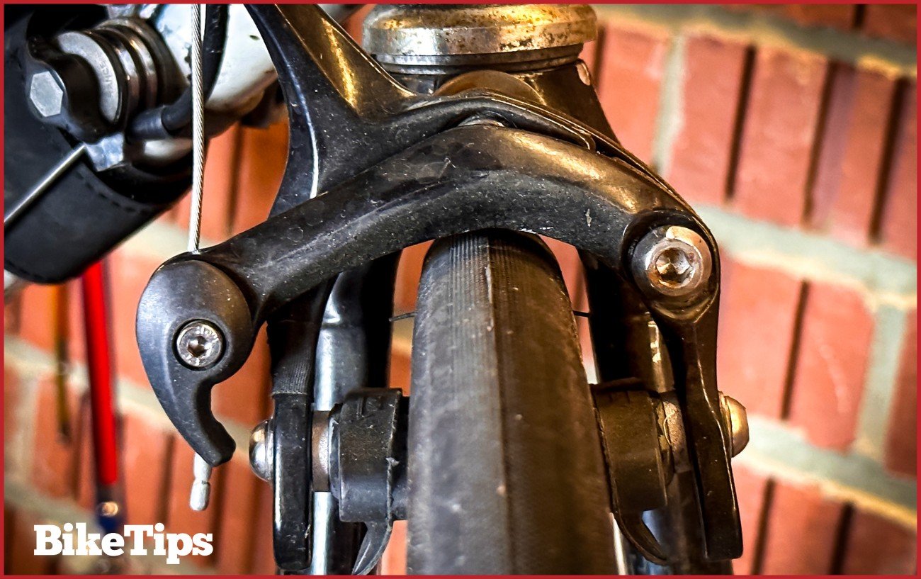A road bike tire and brake in black.