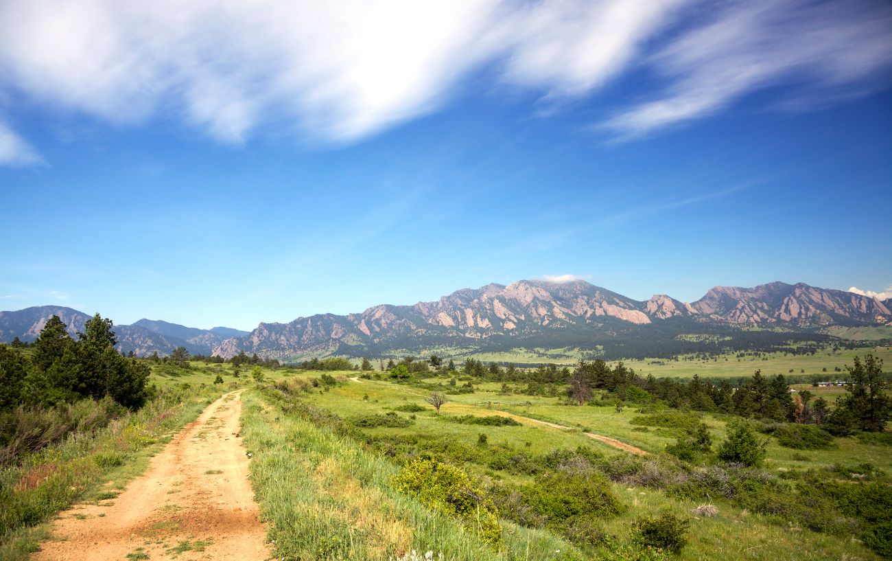 View of an open, grassy plain with mountains in the background while biking the Colorado Trail.